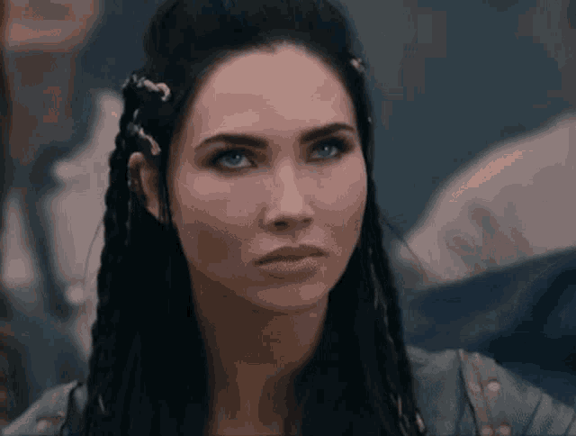 a close up of a woman 's face with braids