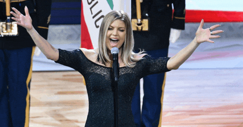 a woman singing into a microphone with a flag behind her that says california on it