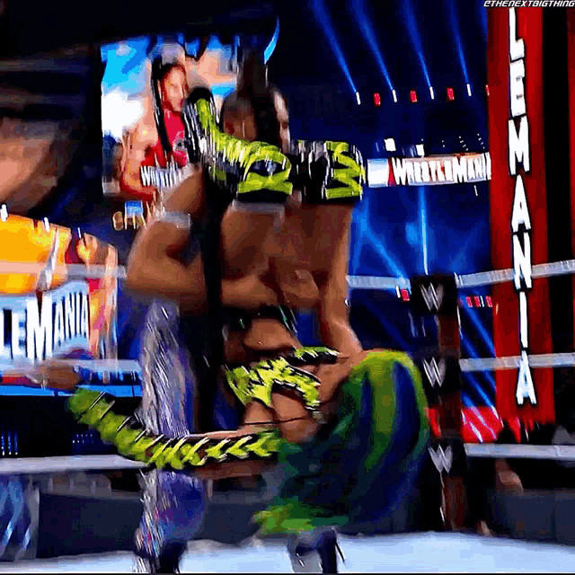 a wrestler is being lifted in the air by another wrestler in a wrestling match