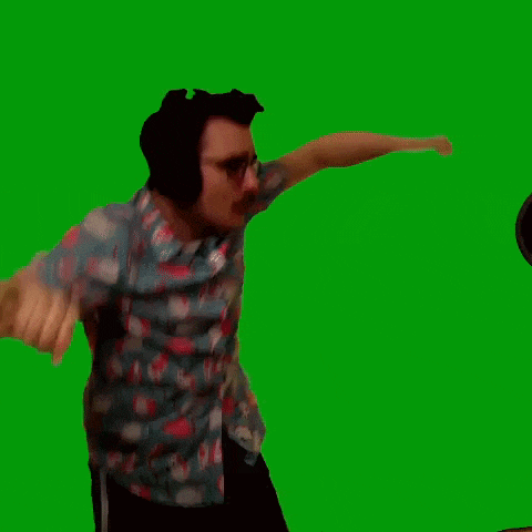 a man is wearing headphones and dancing on a green screen .