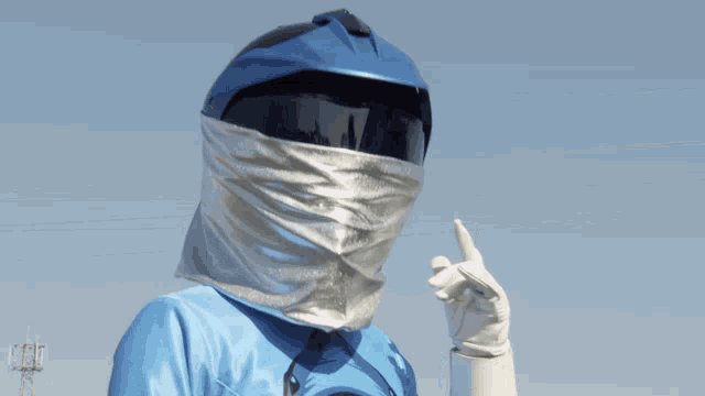 a person wearing a blue helmet and a silver scarf on their head