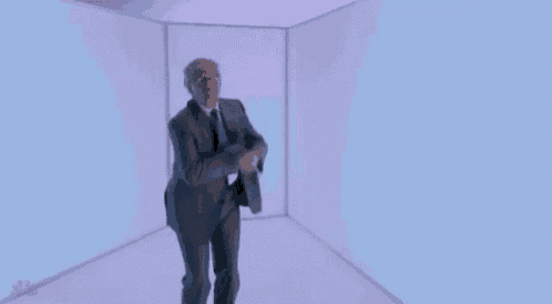 a man in a suit and tie is dancing in a cube .