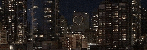 a city skyline with a heart made out of lights on a building .