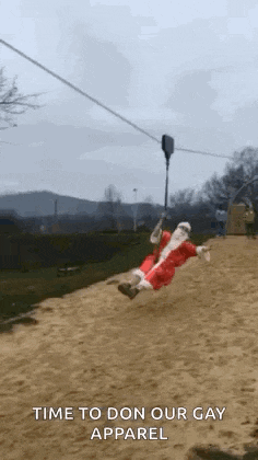 a man dressed as santa claus is riding a zip line .