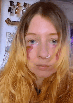 a close up of a woman 's face with sunglasses behind her