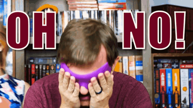 a man covering his face with a purple object and the words oh no behind him