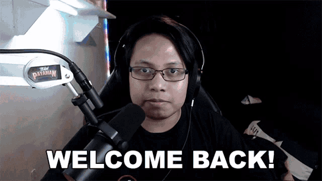 a man wearing glasses and headphones says welcome back in front of a microphone