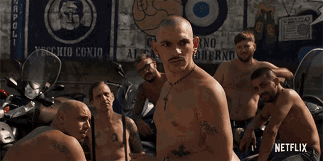 a group of men without shirts are standing in front of a wall that says netflix
