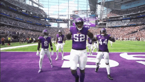 a football player with the number 52 on his jersey celebrates with his teammates