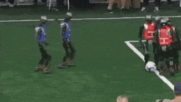 a referee is standing next to a pile of soccer balls on a field .