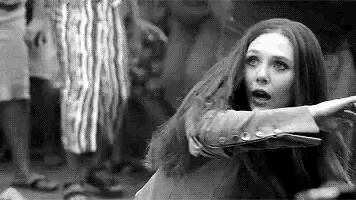a black and white photo of a woman with long red hair standing in a crowd .