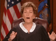 a female judge is sitting in a courtroom with her eyes closed .