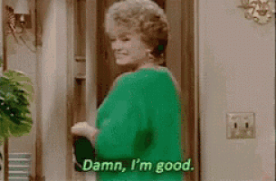 a woman in a green shirt is standing in front of a door and saying `` damn , i 'm good . ''