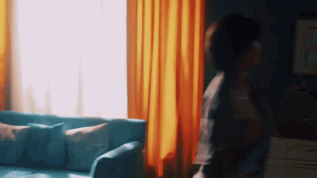 a woman is standing in front of a blue couch