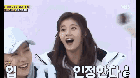 two women are standing next to each other with their mouths open and one of them is wearing a hat .