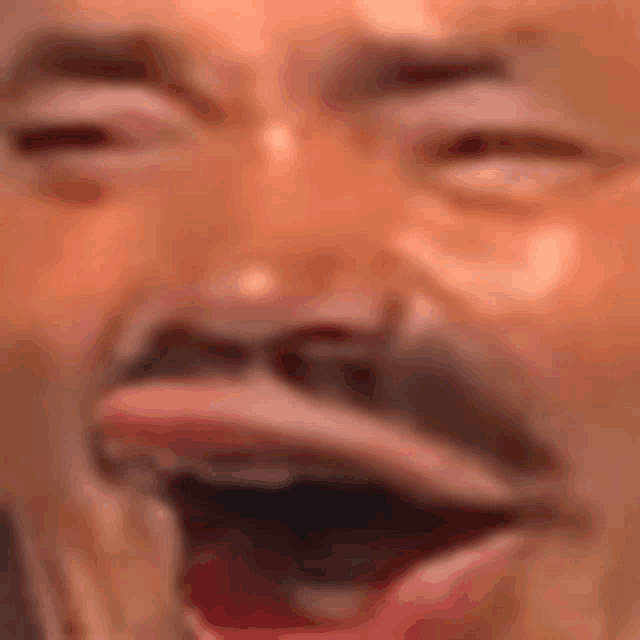 a close up of a man 's face with his mouth wide open .