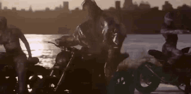 a couple of motorcycles are parked next to each other near a body of water