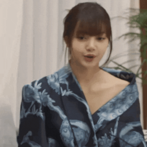 a woman is wearing a blue kimono with a floral pattern