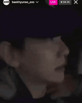 a close up of a person 's face in a dark room with a hat on .