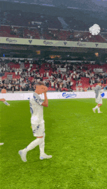 a soccer player with the number 10 on his jersey walks on the field
