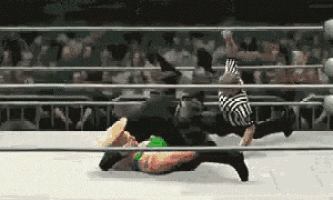two wrestlers are wrestling in a ring with a referee in the background .