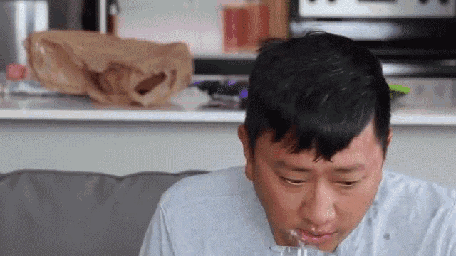 a man is sitting on a couch with his mouth open
