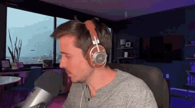 a man wearing headphones is sitting in front of a microphone in a room