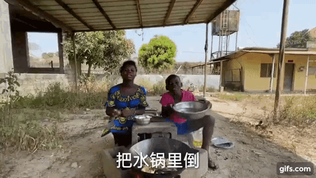 a woman and a boy are sitting under a canopy in front of a building with chinese writing on the ground