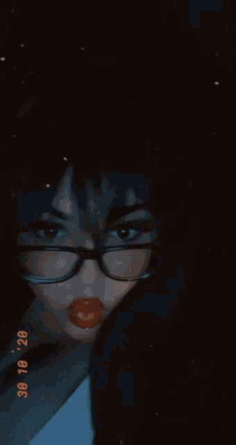 a woman wearing glasses and red lipstick is taking a selfie on 30/10/28