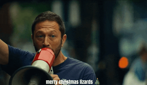 a man holding a megaphone that says merry christmas lizards on it