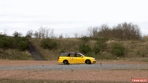 a yellow car is parked on a gravel road with thinkjules written on the bottom left