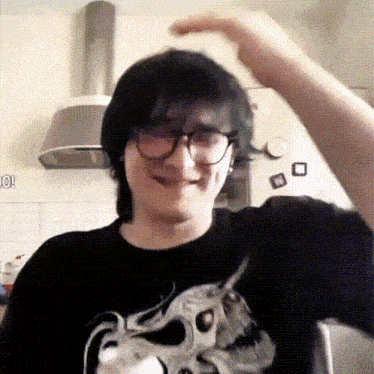 a man wearing glasses and a black shirt with a picture of a skull on it