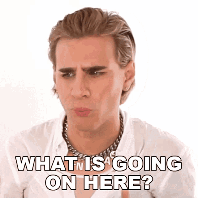 a man wearing a white shirt and a chain around his neck says what is going on here ?