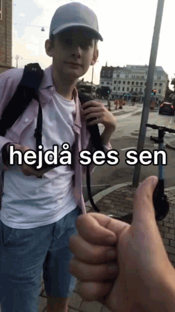 a young man holding a camera with the caption hejda ses sen