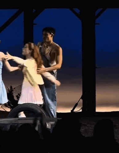 a man and woman are dancing on a stage