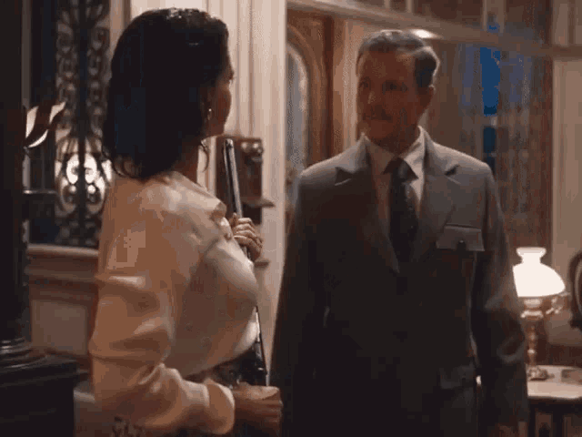 a man and woman are standing next to each other in a room