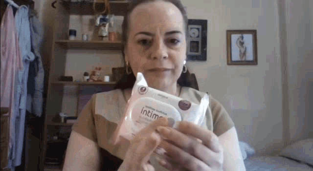 a woman holding a package of intima wipes
