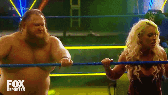 a man and a woman are in a wrestling ring with the fox deportes logo on the bottom