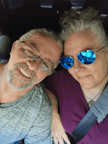 a man and woman wearing sunglasses are posing for a photo