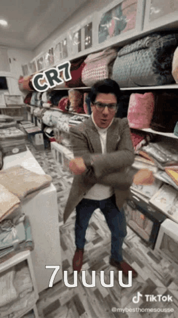 a man is dancing in a store with a sign that says cr7 on it