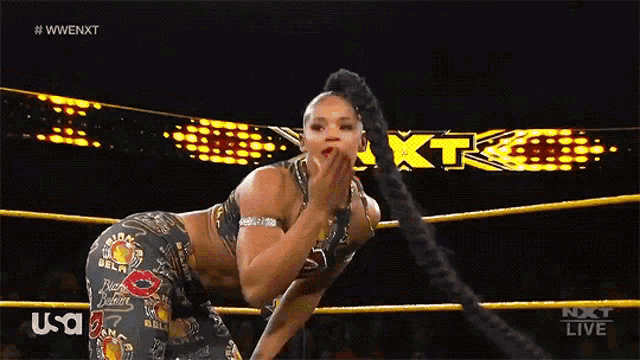 a female wrestler in a wrestling ring with a usa logo behind her
