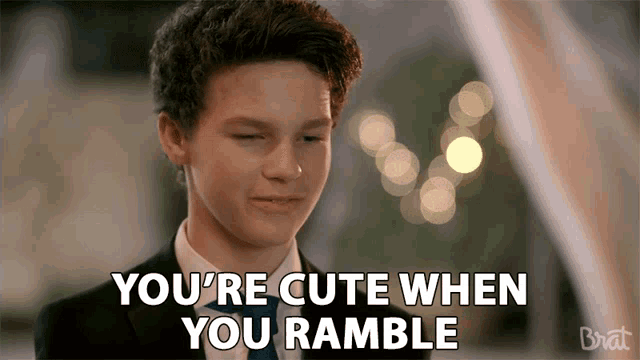 a boy in a suit and tie is saying you 're cute when you ramble