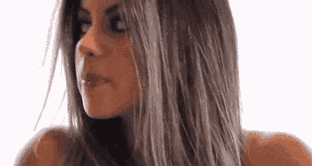 a woman with long hair is making a funny face and looking at the camera .
