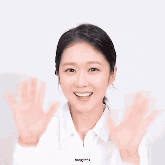 a woman making a heart shape with her hands and the words hongjiahs on the bottom right