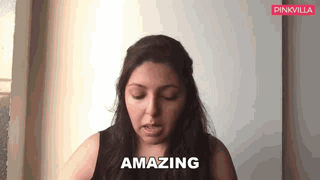 a woman says amazing in front of a white wall