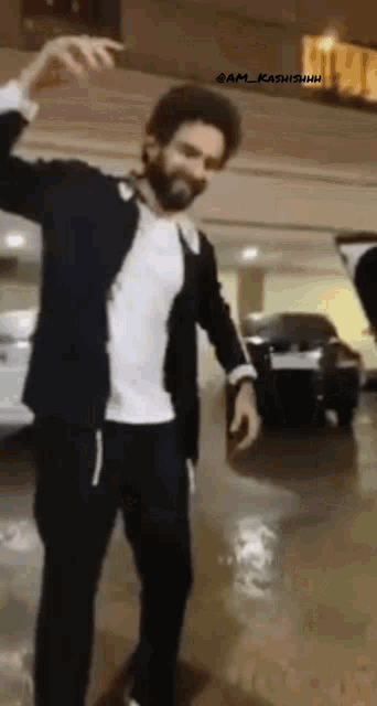 a man in a black jacket and white shirt is dancing