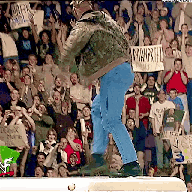 a man stands in front of a crowd with a sign that says manpride