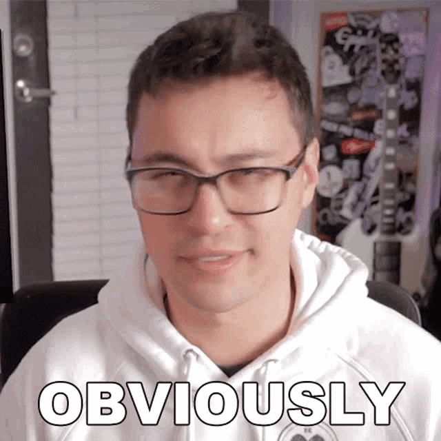a man wearing glasses and a white hoodie has the word obviously on his chest