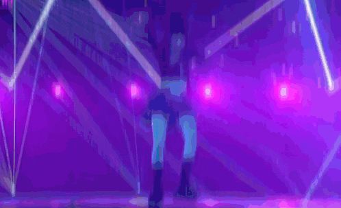 a group of people are dancing on a stage with a blue light behind them that says tokyo on it