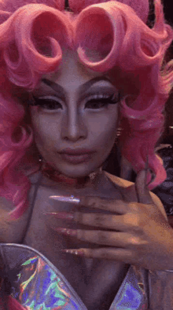 a drag queen wearing a pink wig and a silver dress